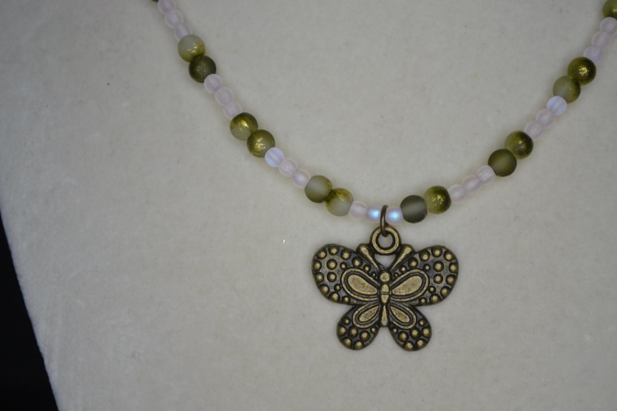 Bronze butterfly pendant glass bead necklace. Frosted pink and frosted green gold