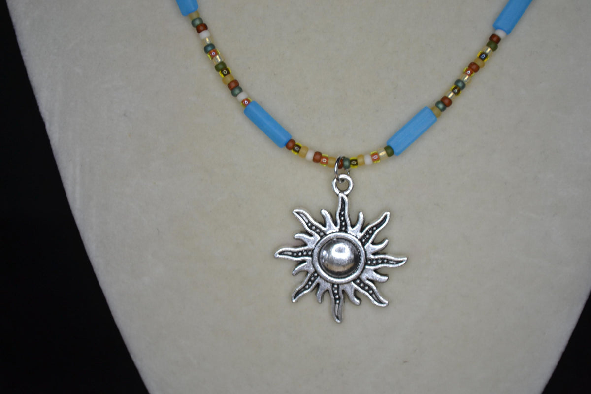 Silver sun pendant glass bead necklace. Matte blue and forest colors