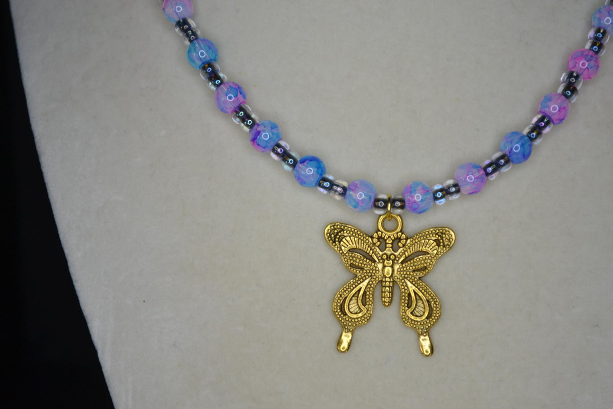 Gold Butterfly pendant glass bead necklace. Blue, pink, and black