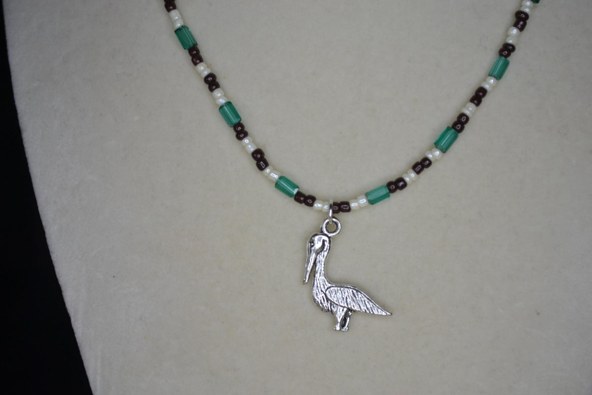 Silver Pelican pendant glass bead necklace. Teal, brown, and white