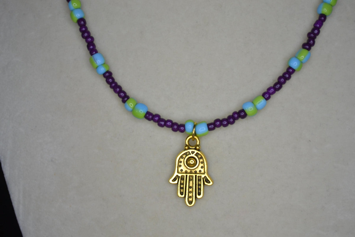 Gold Hamsa pendant glass bead necklace. Dark violet, blue, and green