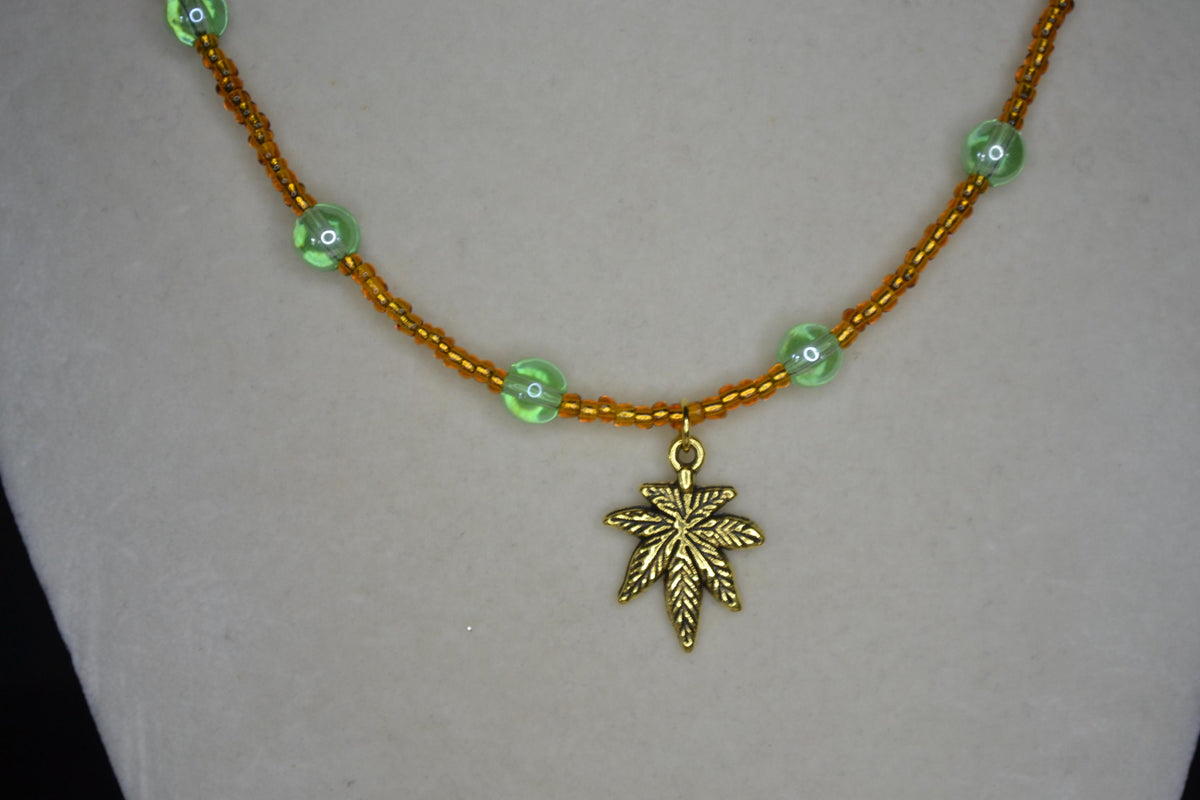 Gold Marijuana Leaf pendant glass bead choker. Brown and green