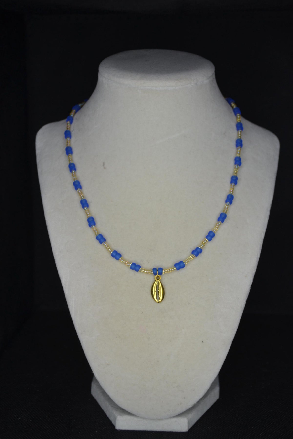 Gold Cowrie shell pendant glass bead necklace. Frosted blue and sand