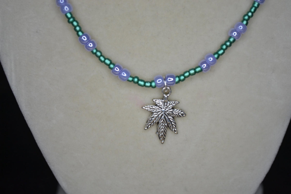 Silver marijuana pendant glass bead necklace. Metallic green and pearlescent lavender