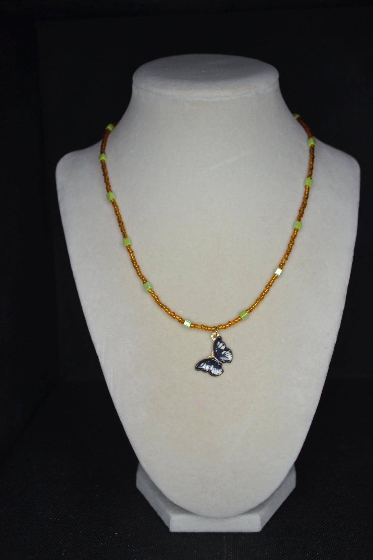 Black Butterfly pendant glass bead necklace. Brown and iridescent green