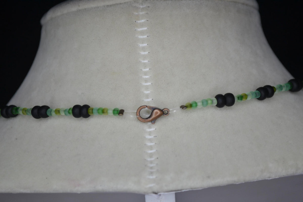 Wire wrapped sharks tooth beaded necklace. Frosted greens and matte black