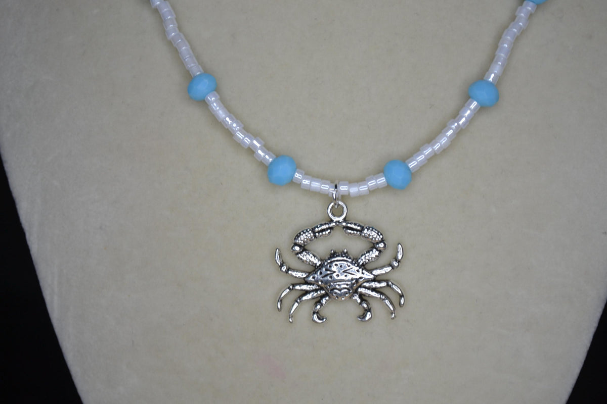 Silver crab pendant glass bead necklace. Blue and white