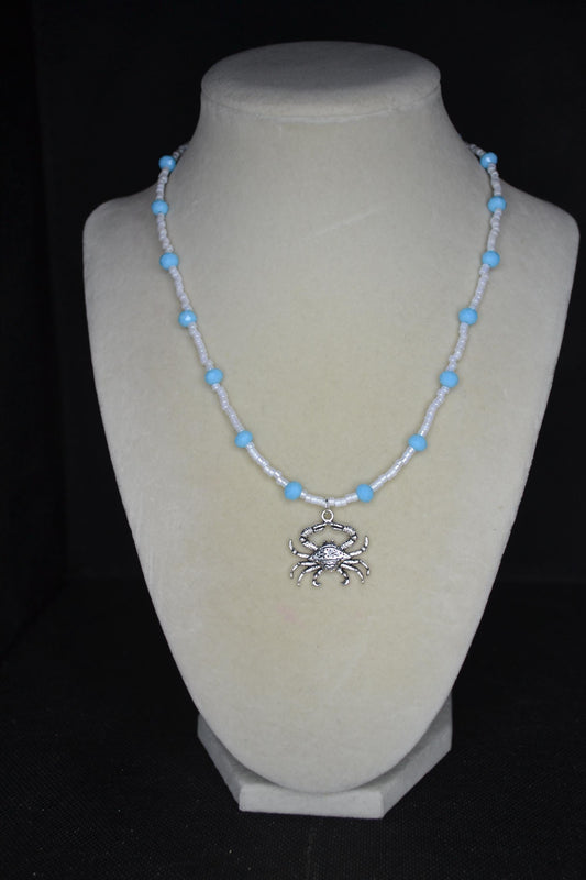 Silver crab pendant glass bead necklace. Blue and white